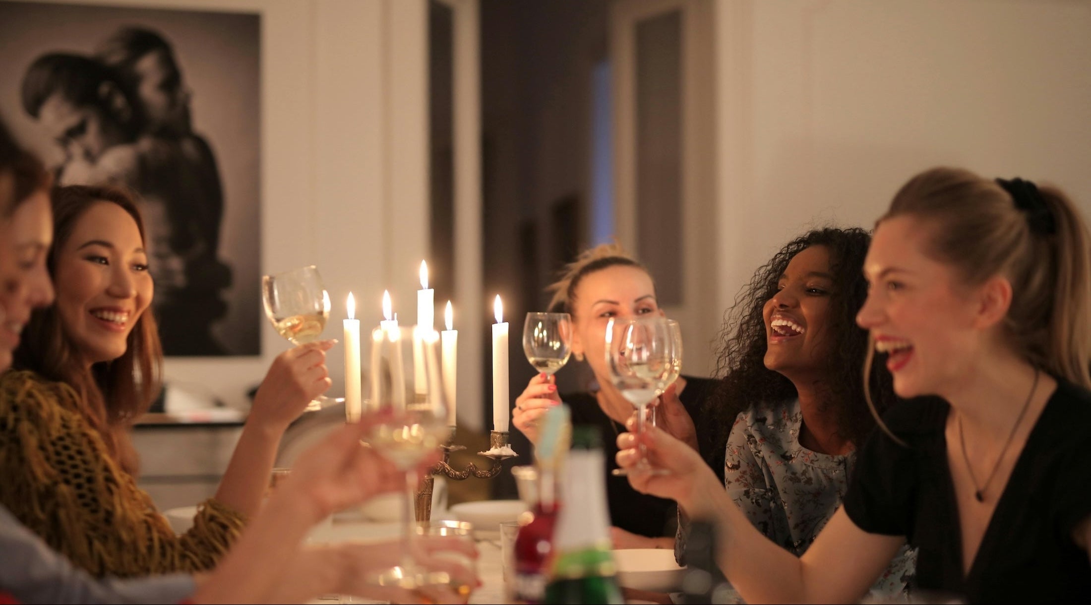 Group of women at dinner party holding wine glasses